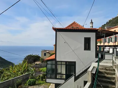 a house on a hill with the ocean in the background at Villa Rodrigues 3 by Rentallido in Campanário