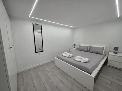 a white bedroom with a bed with towels on it at Villa Rodrigues 3 by Rentallido in Campanário