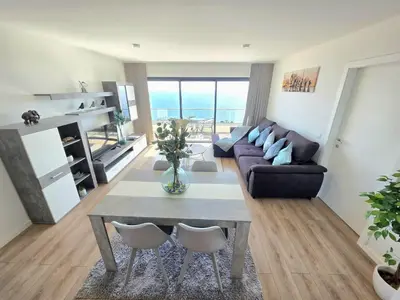 a living room with a table and a couch at Garajau Residence Sea View by Rentallido in Caniço
