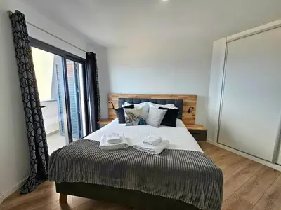 a bedroom with a large bed with shoes on it at Garajau Residence Sea View by Rentallido in Caniço