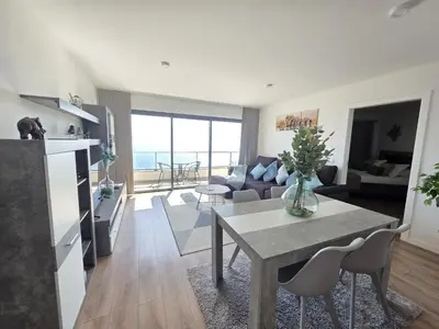 a living room with a table and a couch at Garajau Residence Sea View by Rentallido in Caniço