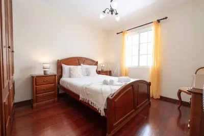 a bedroom with a large bed and a window at Recanto do Estreito by GALMI in Estreito da Calheta