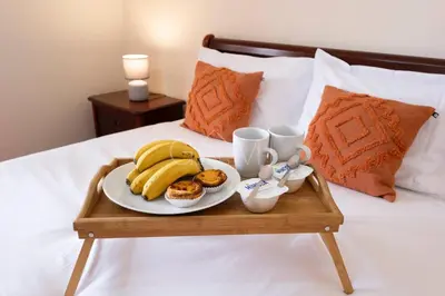 a tray with a plate of food on a bed at Recanto do Estreito by GALMI in Estreito da Calheta