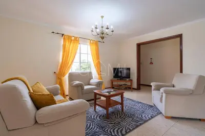 a living room with two couches and a table at Recanto do Estreito by GALMI in Estreito da Calheta