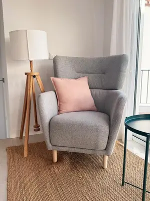 a gray chair with a pink pillow and a lamp at Algarve Windmill, Villa and Pool 2000m to the Beach in Figueira