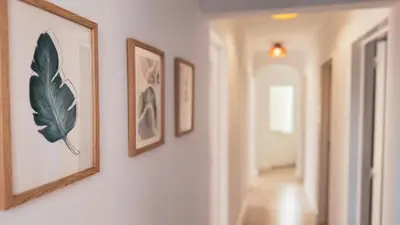 a hallway with framed pictures on a wall at Algarve Windmill, Villa and Pool 2000m to the Beach in Figueira