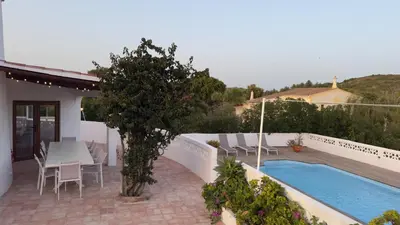 a patio with a table and chairs and a swimming pool at Algarve Windmill, Villa and Pool 2000m to the Beach in Figueira