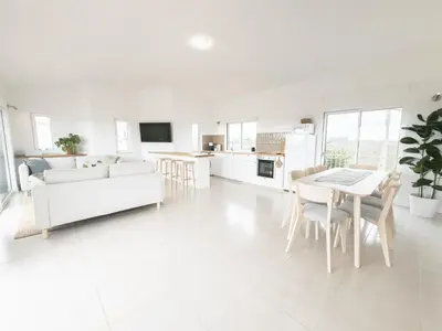 a white living room with a white couch and a table at Algarve Windmill, Villa and Pool 2000m to the Beach in Figueira