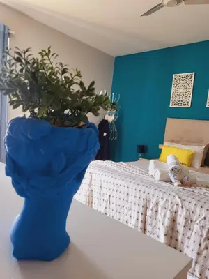 a blue vase with a plant in a bedroom at Home Personal Funchal 1 in Funchal