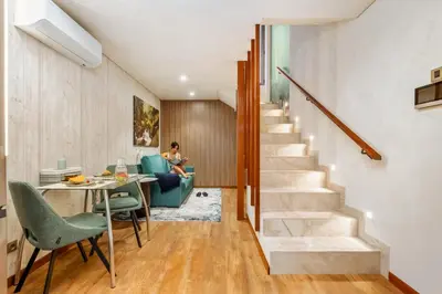 a staircase in a house with a woman sitting on a couch at Marrom Mystique in Canhas