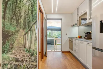 a kitchen with a forest mural on the wall at Marrom Mystique in Canhas