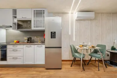 a kitchen with a refrigerator and a table with chairs at Marrom Mystique in Canhas