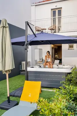 a woman sitting under an umbrella in a backyard at Marrom Mystique in Canhas