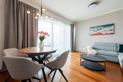 a living room with a table and chairs and a couch at Sky View - Spacious Stay with Pool & Gym in Funchal