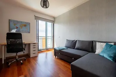 a living room with a couch and a desk and a chair at Sky View - Spacious Stay with Pool & Gym in Funchal