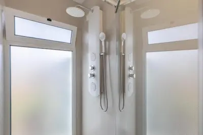 a bathroom with two doors and a window at Scenic Home with Panoramic Sea & Mountain Views in São Vicente in São Vicente