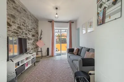 a living room with a couch and a tv at Scenic Home with Panoramic Sea & Mountain Views in São Vicente in São Vicente
