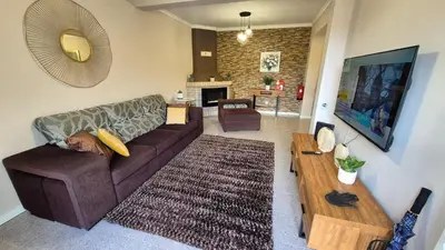 a living room with a couch and a fireplace at Chalé da Serra in Santo da Serra