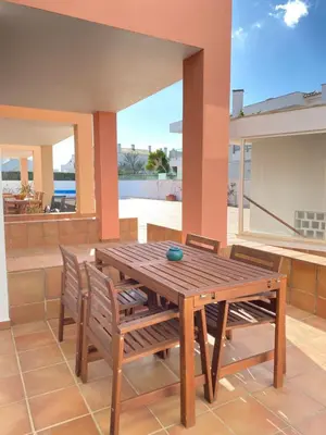 a wooden table and chairs on a patio at Porto de Abrigo in Burgau