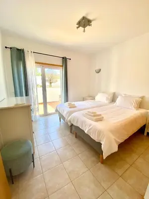 a bedroom with a large bed and a window at Porto de Abrigo in Burgau