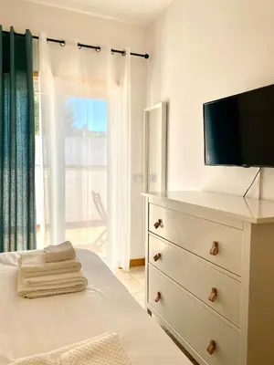 a bedroom with a dresser with a tv on it at Porto de Abrigo in Burgau
