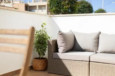 a couch sitting on a balcony with a potted plant at Porto de Abrigo in Burgau