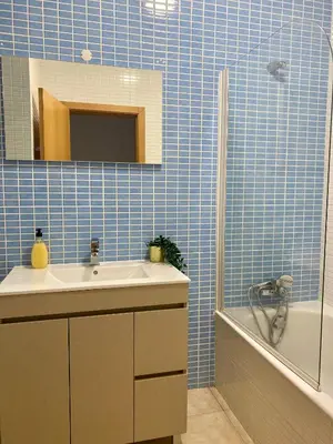 a blue tiled bathroom with a sink and a tub at Porto de Abrigo in Burgau