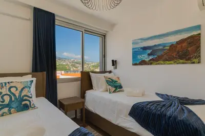 a bathroom with a white sink and a mirror at Pearl Retreat by Holiday Rental Madeira in Câmara de Lobos