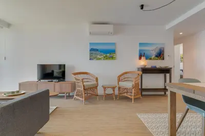 a living room with a couch and a table at Pearl Retreat by Holiday Rental Madeira in Câmara de Lobos