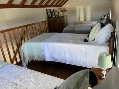 a bedroom with two beds and a staircase at Casa Herbarium in Prazeres