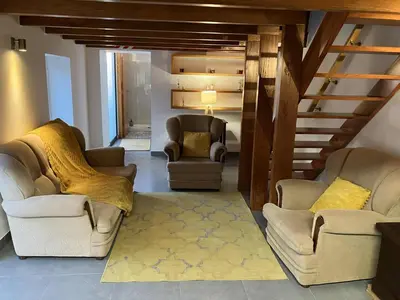 a living room with two chairs and a staircase at Casa Herbarium in Prazeres