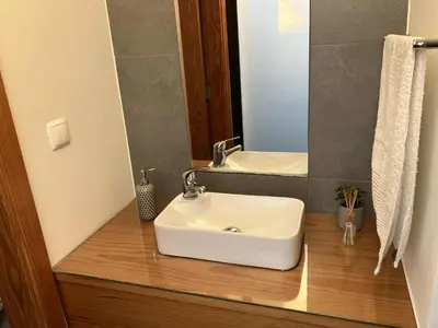 a bathroom with a white sink and a mirror at Casa Herbarium in Prazeres