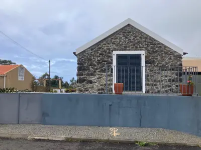 a house with a stone wall and a window at Casa Herbarium in Prazeres