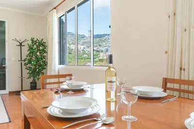 a table with a bottle of wine and glasses on it at Casa do Pico by Atlantic Holiday in Câmara de Lobos