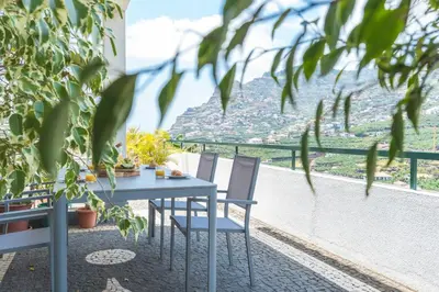 a table and chairs on a balcony with a view at Casa do Pico by Atlantic Holiday in Câmara de Lobos