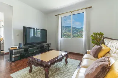a living room with a television and a coffee table at Casa do Pico by Atlantic Holiday in Câmara de Lobos