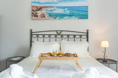 a tray of fruit on a bed with a table at Casa do Pico by Atlantic Holiday in Câmara de Lobos