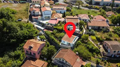 a house with a red arrow in a residential neighborhood at Joana's House in Camacha