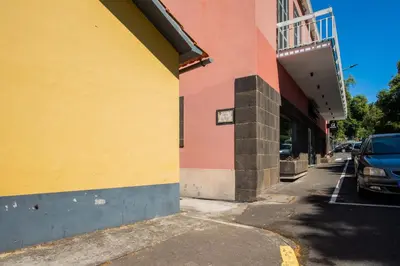 a yellow and pink building next to a street at Joana's House in Camacha
