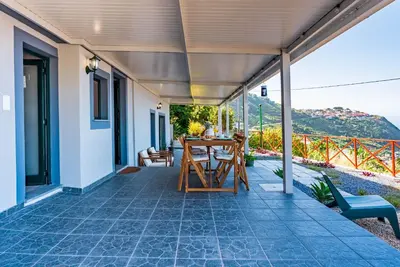 a patio with a table and chairs on a house at Casa D'Avó Bela in Arco da Calheta