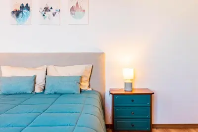 a bedroom with a blue bed and a nightstand at Casa D'Avó Bela in Arco da Calheta