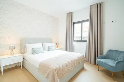 a bedroom with a bed and a blue chair at Nora Charming Apartment - Pool -10m Walk City Center in Funchal