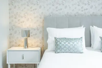 a bedroom with two beds with white pillows and a night stand at Nora Charming Apartment - Pool -10m Walk City Center in Funchal
