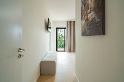 a white room with a bed and a painting on the wall at Nora Charming Apartment - Pool -10m Walk City Center in Funchal