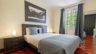 a bedroom with a large bed and a window at Machico Village by LovelyStay in Machico