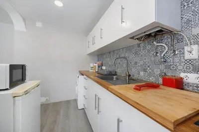 a kitchen with white cabinets and a sink at Apartamento Carrapateira in Bordeira