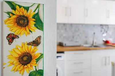 a painting of sunflowers and butterflies on a kitchen door at Apartamento Carrapateira in Bordeira