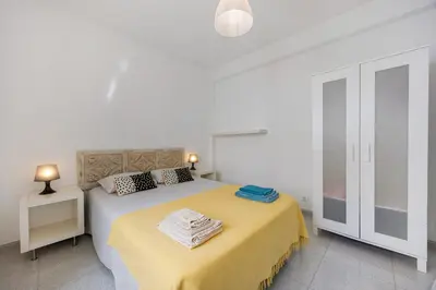 a white bedroom with a bed with a yellow blanket at Apartamento Carrapateira in Bordeira