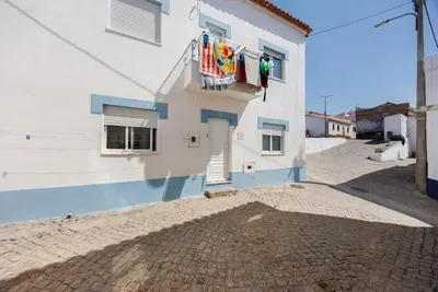 a blue and white building with a door and two windows at Apartamento Carrapateira in Bordeira