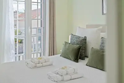 a white bed with towels on it with a window at Achada by Homie in Funchal